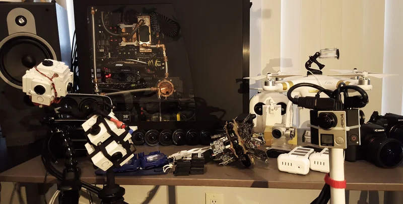 Workbench/collection of previous research camera builds including cardboard arrays and 360 prototypes.