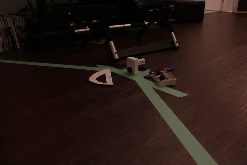 Research setup with small cameras on floor markings/tripod and a camera mount model.