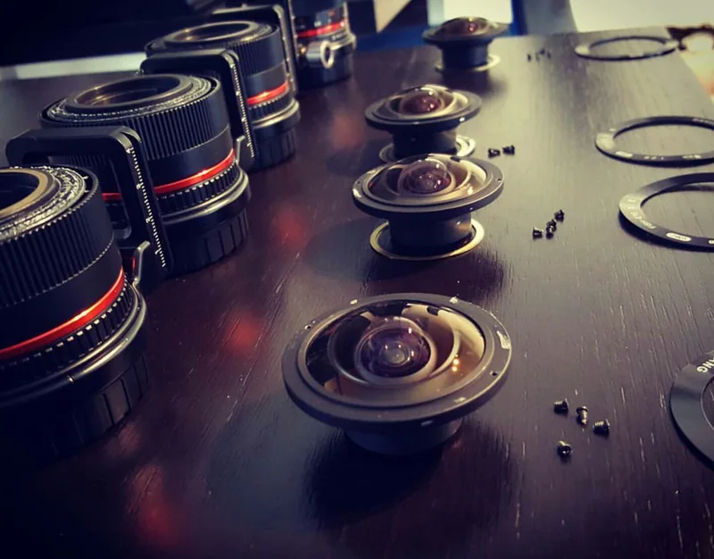 Screenshot/export of photograph showing disassembled lens components.