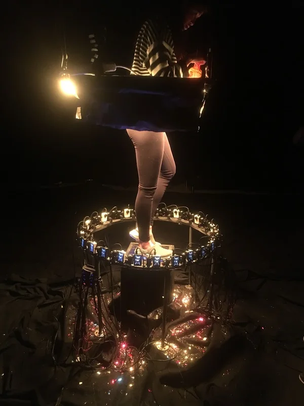Performer standing inside illuminated bullet-time camera ring.