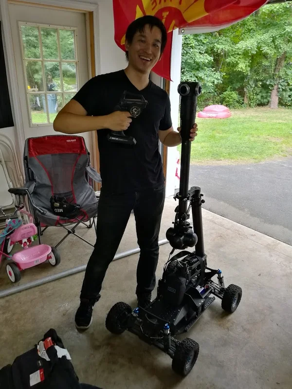 Person handling a camera support rig in a workshop.