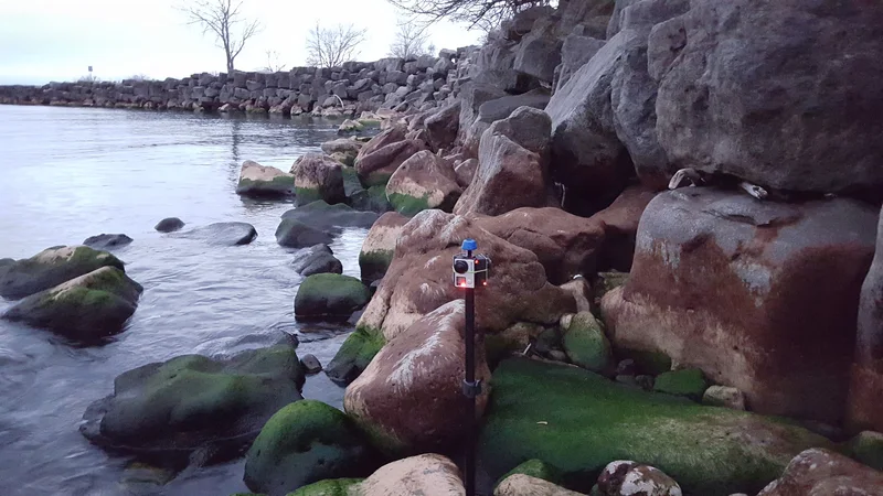 Camera setup on rocky lakeshore demonstrating outdoor use.