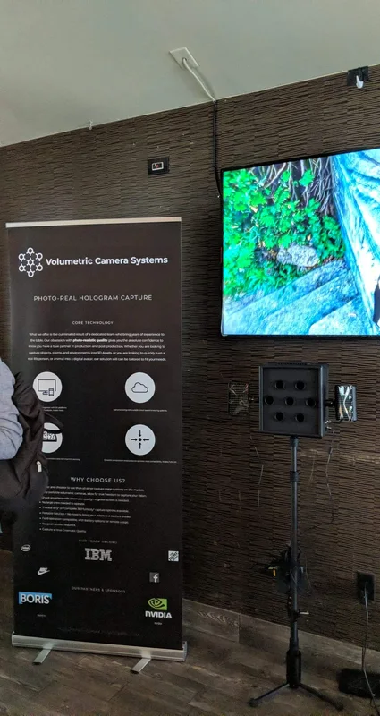 Vertical view of VCS banner and compact camera below the wall-mounted volumetric display at South by Southwest.